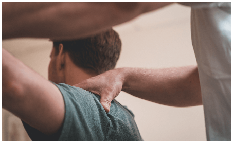  Fysioterapeut undersöker en patients axel